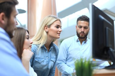 Ofis Masası oturma ve Pc vasıl birlikte bakarken bir şey tartışırken rahat kıyafet içinde gençlerin Grup.