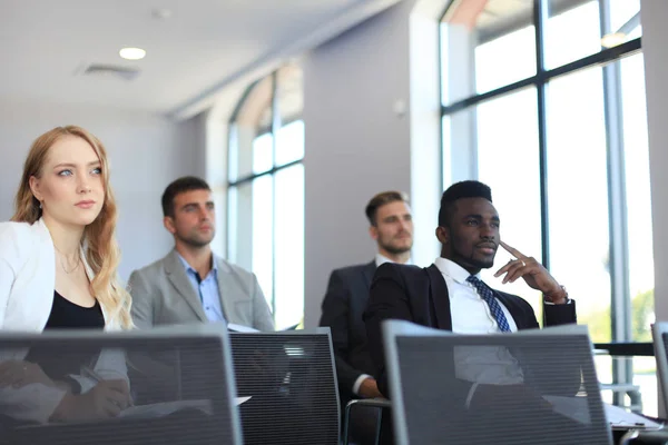 Groupe d'hommes d'affaires assis en conférence à la parole tout en ayant réunion d'affaires . — Photo