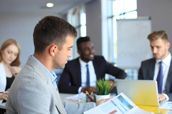 Affärsman med kollegor i bakgrunden på kontoret. — Stockfoto