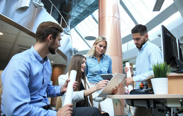 Gruppo di giovani moderni in abbigliamento casual intelligente con un incontro di brainstorming mentre in piedi nell'ufficio creativo . — Foto Stock