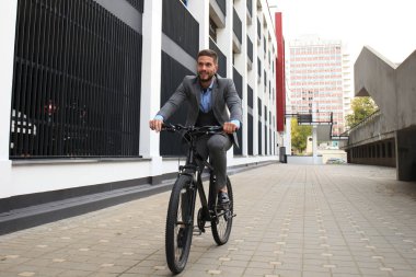 Yakışıklı genç işadamı binicilik bisiklet açık havada şehirde.