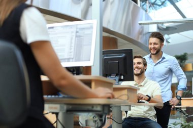 Ofiste zaman geçirirken bilgisayarla veri analiz eden kendinden emin genç iş adamları..