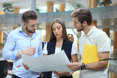 Smart casual modern gençlerin grup giymek bir beyin fırtınası dururken yaratıcı ofiste toplantısı.