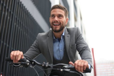 Yakışıklı genç işadamı binicilik bisiklet açık havada şehirde.