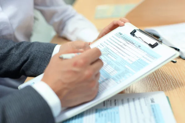 Mann füllt Einkommensteuererklärung aus, Steuer 1040 / 6. — Stockfoto