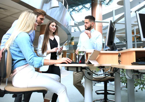 Ofis Masası oturma ve Pc vasıl birlikte bakarken bir şey tartışırken rahat kıyafet içinde gençlerin Grup.