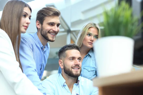 Grupo de jóvenes modernos en ropa casual inteligente que tienen una reunión de tormenta de ideas mientras están de pie en la oficina creativa . — Foto de Stock