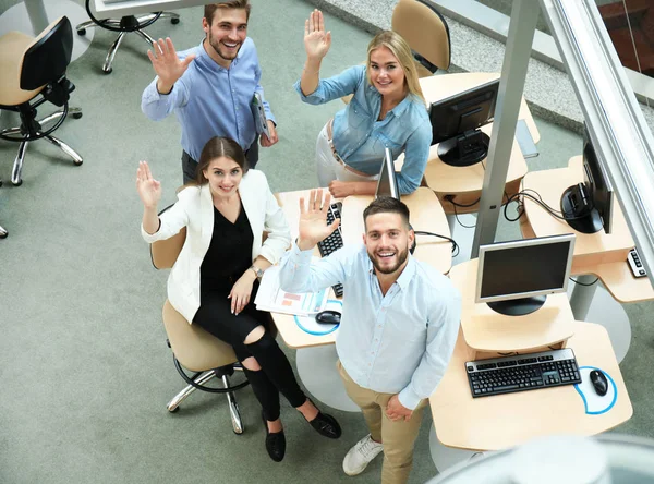 Vedere de top a tinerilor colegi moderni în îmbrăcăminte casual inteligentă care lucrează împreună în timp ce petrec timp la birou . — Fotografie, imagine de stoc
