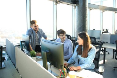 Ofis Masası oturma ve Pc vasıl birlikte bakarken bir şey tartışırken rahat kıyafet içinde gençlerin Grup.