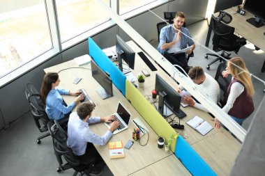 Genç modern iş arkadaşları birlikte ofiste vakit süre çalışan akıllı rahat kıyafet üstten görünüm.