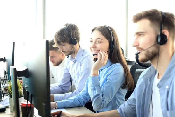 Retrato da funcionária do call center acompanhada por sua equipe. Smiling operador de suporte ao cliente no trabalho. — Fotografia de Stock