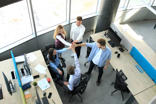 Vista dall'alto dei giovani colleghi moderni in abbigliamento casual intelligente che lavorano insieme mentre trascorrono del tempo in ufficio . — Foto Stock