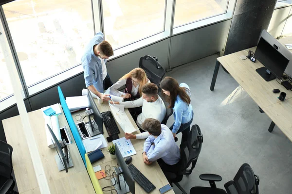 Bovenaanzicht van jonge moderne collega's in slimme vrijetijdskleding, samen te werken terwijl de tijd doorbrengen in het kantoor. — Stockfoto
