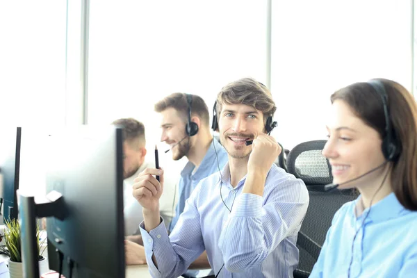 Портрет співробітника колл-центру у супроводі його команди. Усміхнений оператор підтримки клієнтів на роботі . — стокове фото