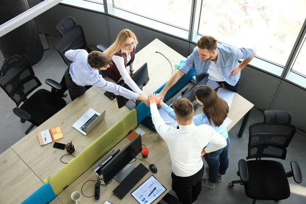 Blick von oben auf junge moderne Kollegen in schicker Freizeitkleidung, die gemeinsam Zeit im Büro verbringen. — Stockfoto