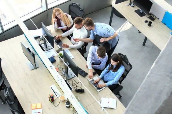 Bovenaanzicht van buiness team brainstormen zittend aan de office-tafel samen. — Stockfoto