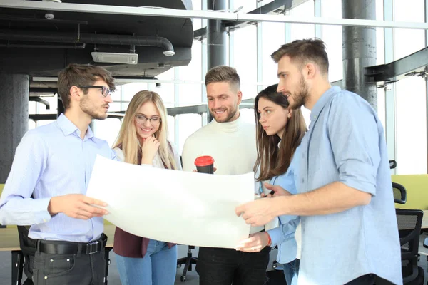 Grupo de jóvenes empresarios y diseñadores en ropa casual inteligente. Están trabajando en un nuevo proyecto . — Foto de Stock