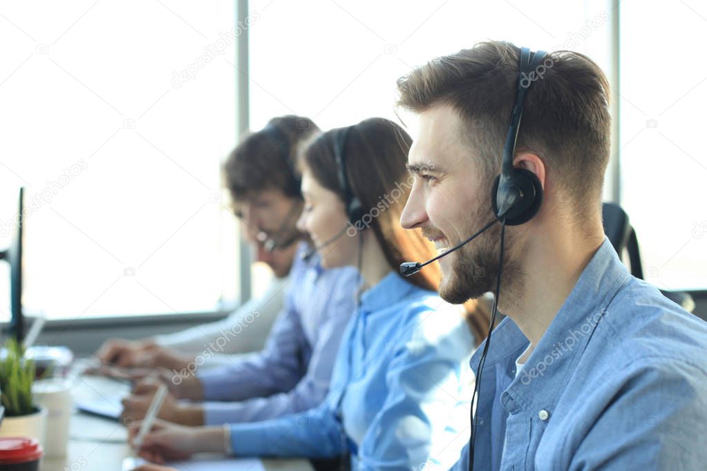 Attractive positive young businesspeople and colleagues in a call center office.