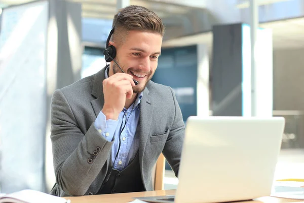 Lachend vriendelijke knappe jonge mannelijke call center operator. — Stockfoto