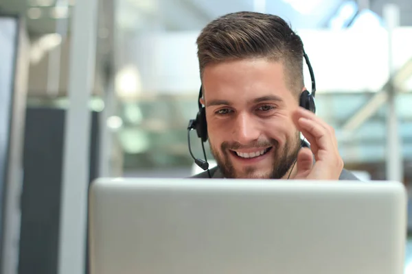 Freundlich lächelnde hübsche junge männliche Callcenter-Betreiber. — Stockfoto