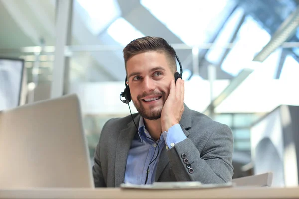 Lachend vriendelijke knappe jonge mannelijke call center operator. — Stockfoto