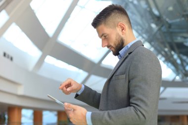 İşadamı içinde yazıhane şeffaf tablet ve dizüstü bilgisayar ile çalışma.