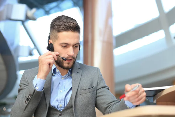 Lachend vriendelijke knappe jonge mannelijke call center operator. — Stockfoto