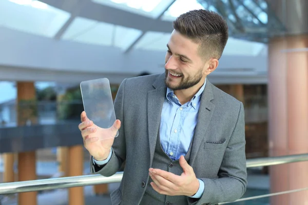 Concepto futuro. Empresario sostiene futurista teléfono inteligente transparente . — Foto de Stock