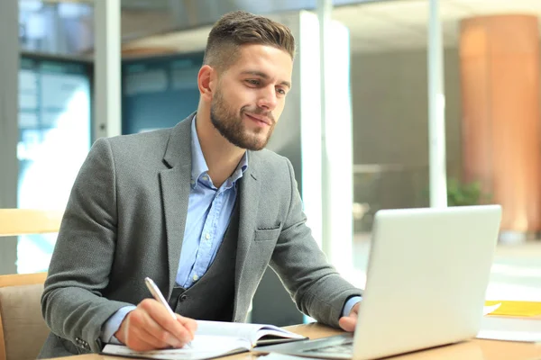 Retrato del joven sentado en su escritorio en la oficina. — Foto de Stock