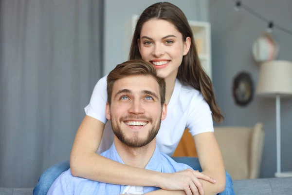Beautiful woman with boyfriend spending quality time together on sofa at home in the living room. — Stock Photo, Image