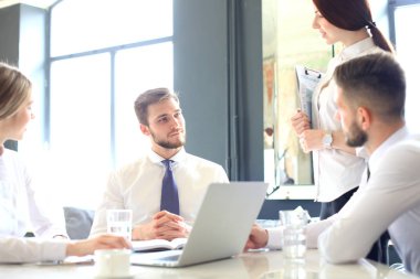 Bir grup iş ortağı ofiste fikir ve planlama işini tartışıyor..