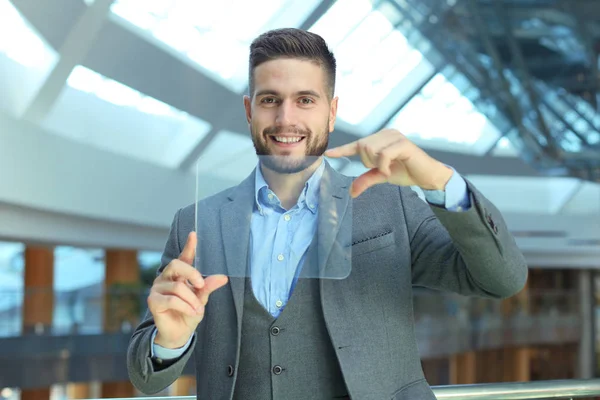 Empresário trabalhando no escritório com tablet transparente e laptop . — Fotografia de Stock