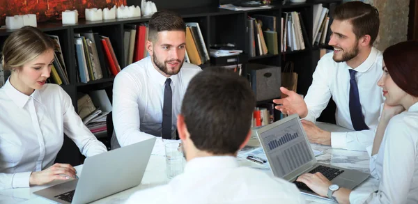 Team van zakenmensen met discussie aan tafel in creatief kantoor. — Stockfoto