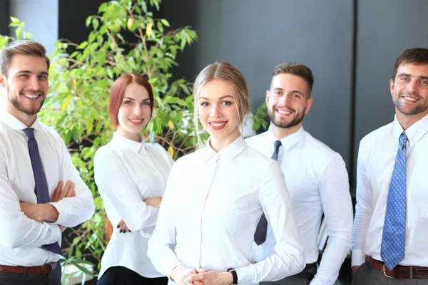 Feliz joven mujer de negocios de pie frente a su equipo . — Foto de Stock