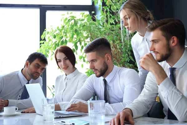 Business team werkt aan laptop om de resultaten van hun werk te controleren. — Stockfoto