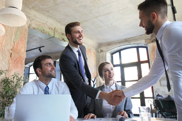 Zakenman schudden handen om te verzegelen een deal met zijn partner en collega's in Office. — Stockfoto