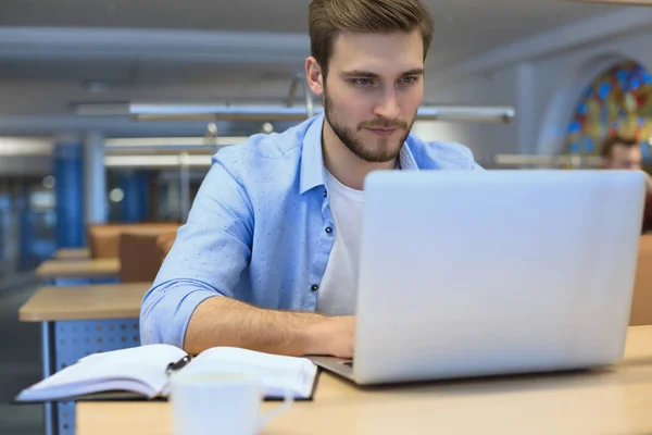 Retrato del joven sentado en su escritorio en la oficina. — Foto de Stock