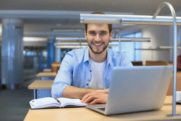 Retrato del joven sentado en su escritorio en la oficina. — Foto de Stock