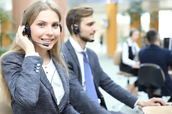 Operadora de suporte ao cliente feminina com fone de ouvido e sorrindo. — Fotografia de Stock