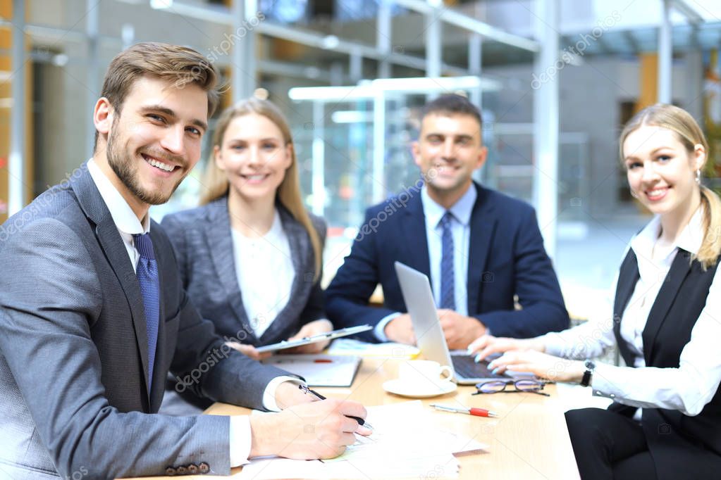 Businessman with colleagues in the background in office.