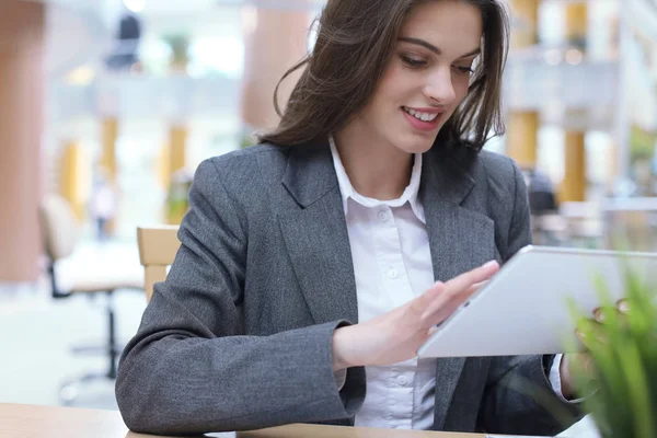 Jeune femme d'affaires souriante au bureau travaillant sur tablette numérique . — Photo