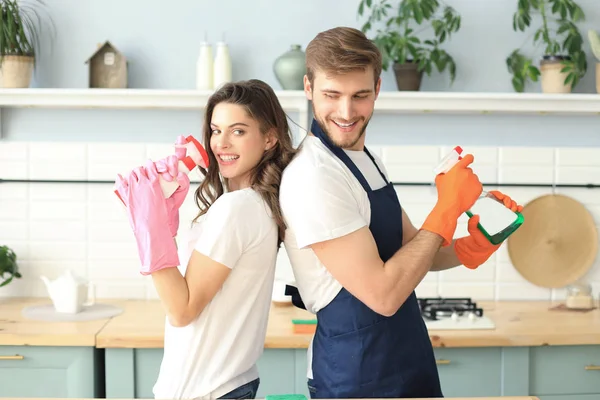若い幸せなカップルは家で掃除をしながら楽しんでいます. — ストック写真