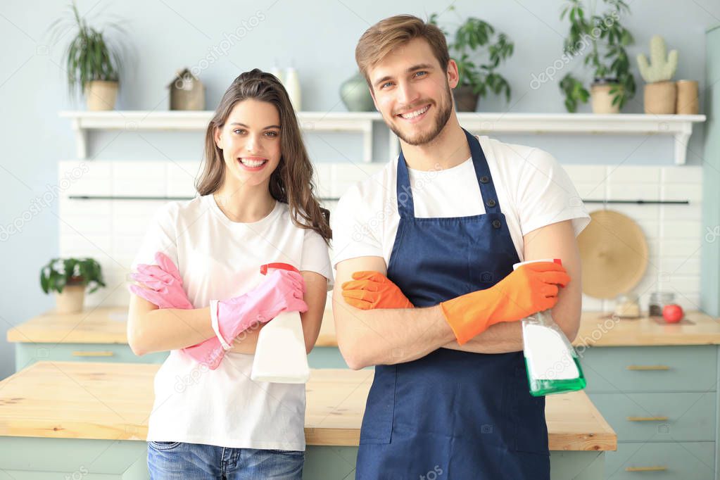 Young happy couple is having fun while doing cleaning at home.