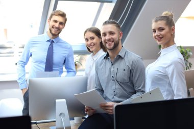 Ofisin arka planında bir grup başarılı iş adamı.