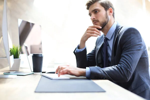 Σύγχρονος επιχειρηματίας που σκέφτεται κάτι ενώ κάθεται στο γραφείο. — Φωτογραφία Αρχείου