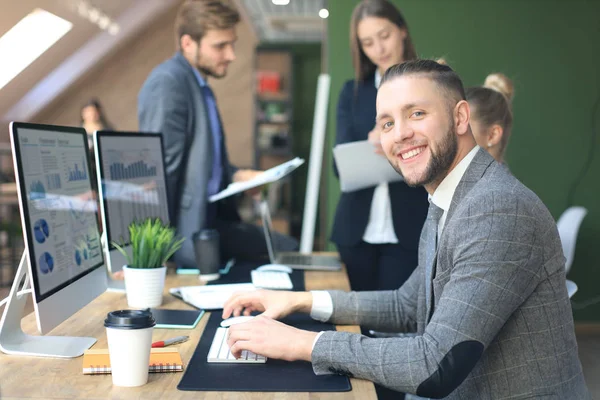 Empresario con colegas en segundo plano en la oficina. — Foto de Stock