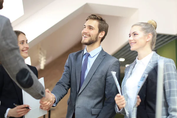 Partner commerciali che stringono le mani sugli oggetti aziendali sul posto di lavoro. — Foto Stock