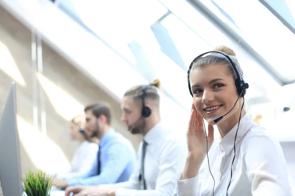 Operadora de atención al cliente femenina con auriculares y sonrisa. —  Fotos de Stock