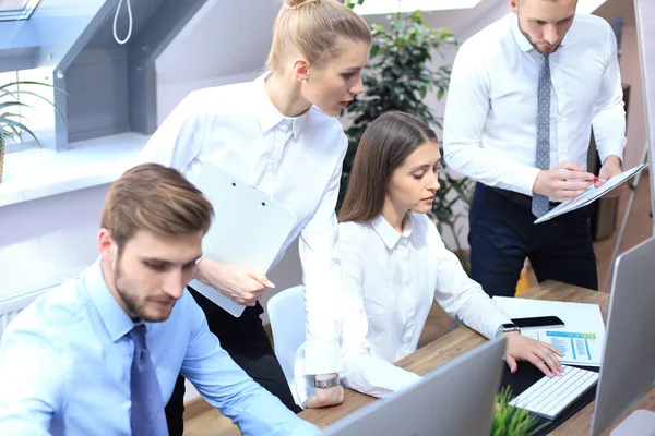 Jóvenes empresarios que trabajan en sus ordenadores de sobremesa en el moderno espacio de oficinas . —  Fotos de Stock