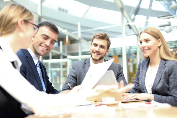 Group of business partners discussing ideas and planning work in office.